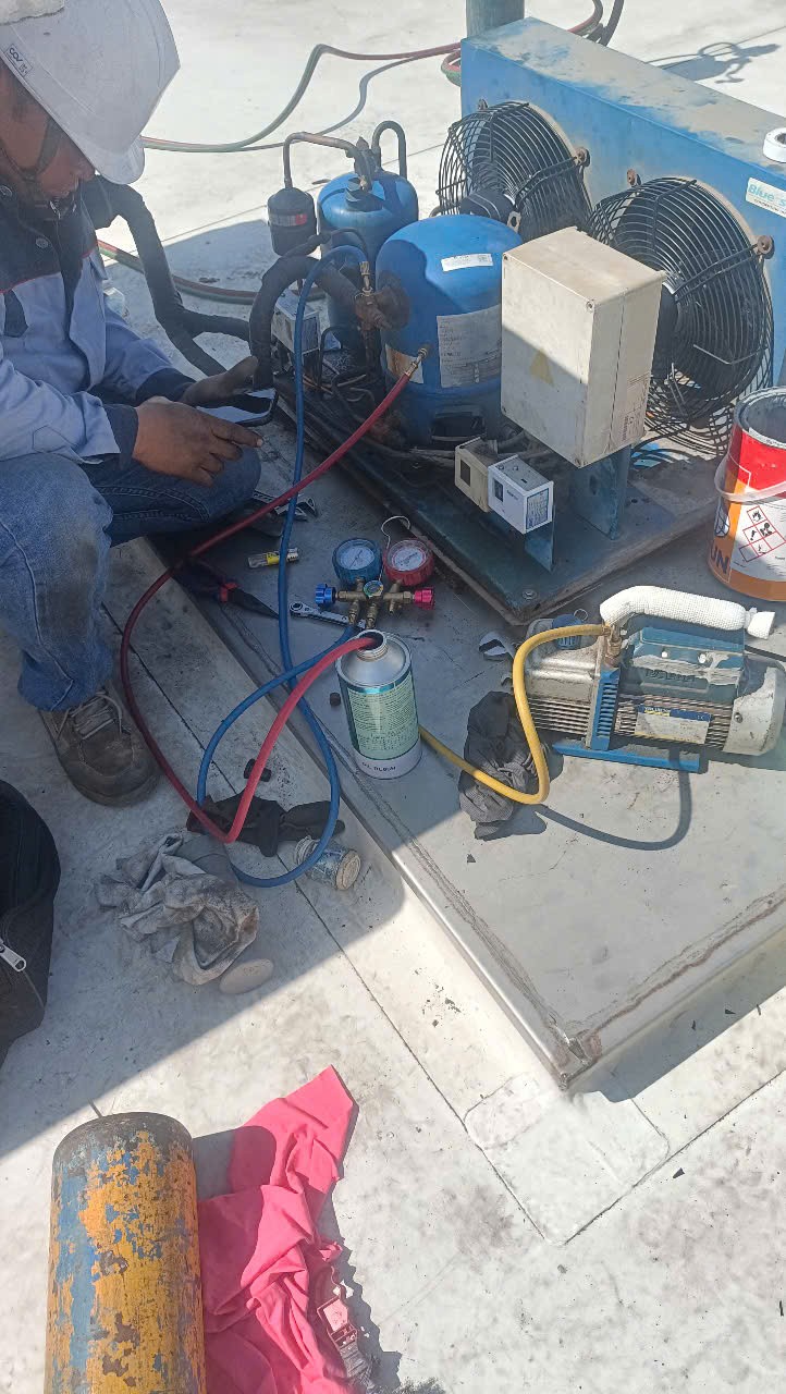 refrigeration technician fixing a cold storage unit
