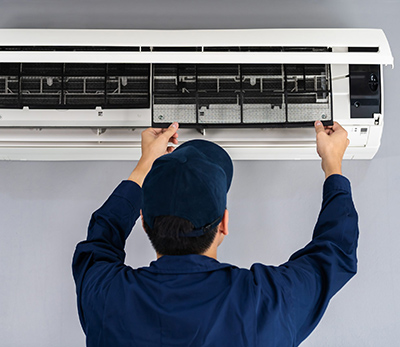 air conditioner repair technician inspecting unit