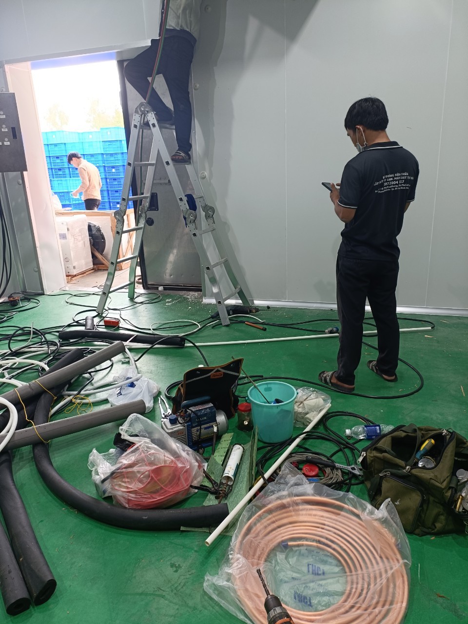 technician repairing air conditioner in Bến Cát