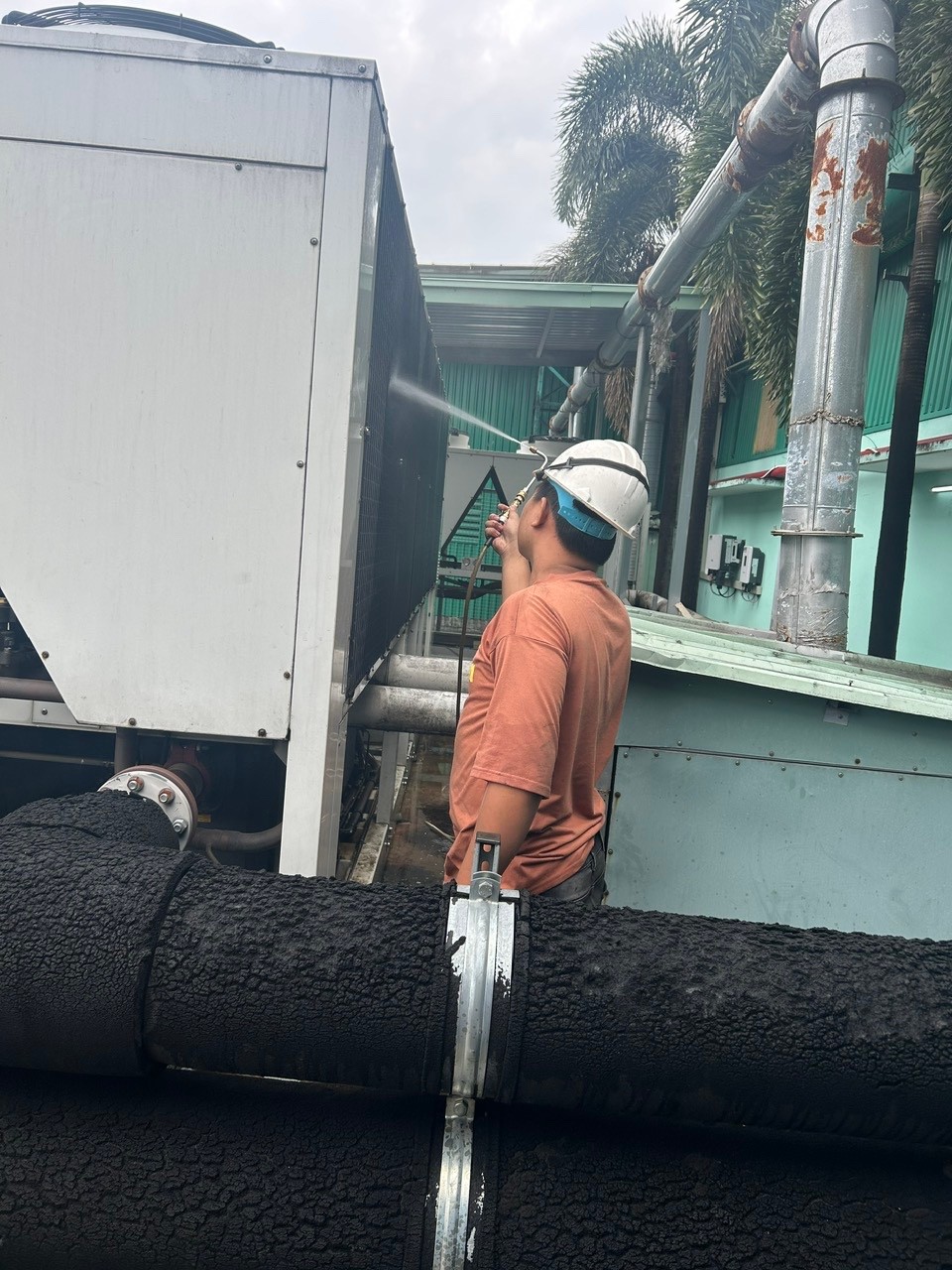 technician cleaning industrial air conditioner