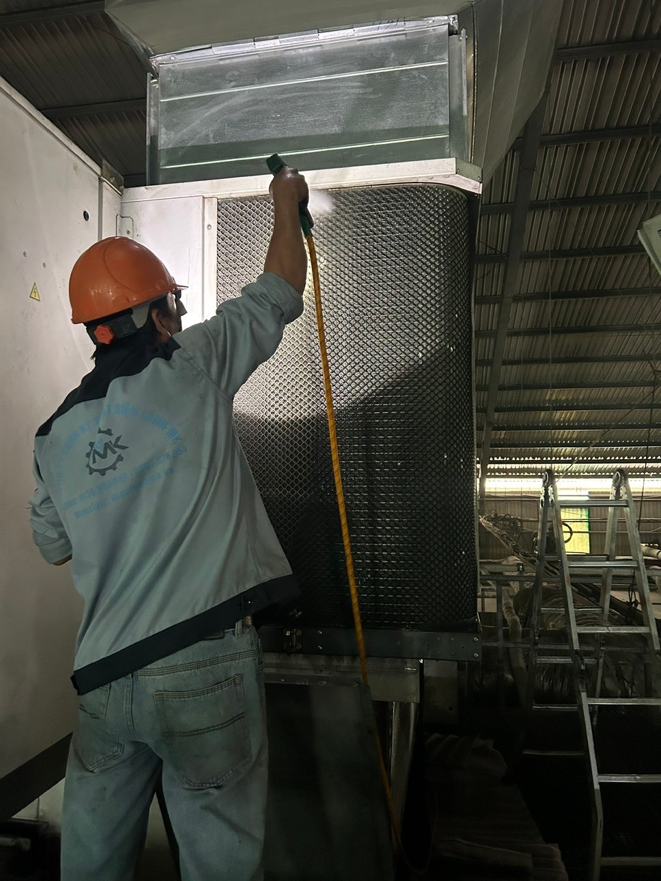 technician cleaning industrial air conditioner coil