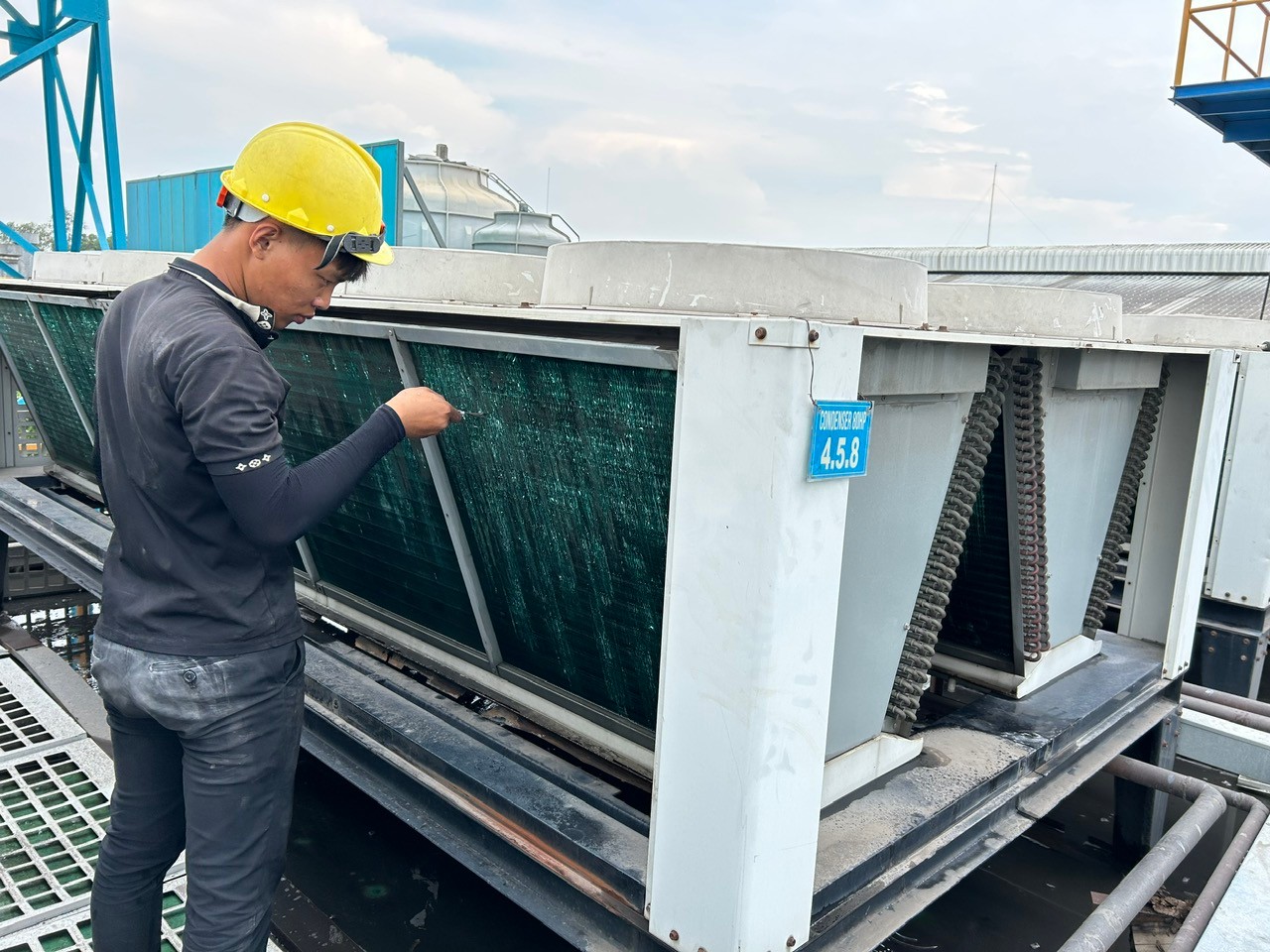 technician cleaning industrial air conditioner